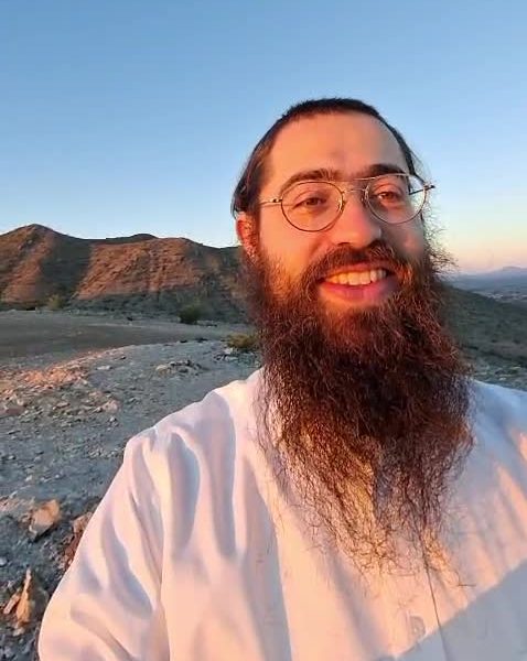 Yitzchok Grossman smiling outdoors at sunrise in Arizona